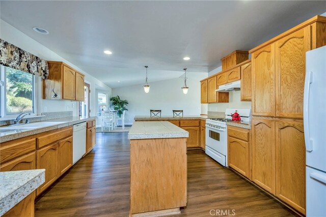 kitchen with a center island, dark wood-type flooring, lofted ceiling, white appliances, and decorative light fixtures