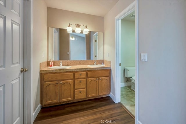 bathroom featuring vanity, toilet, and hardwood / wood-style flooring