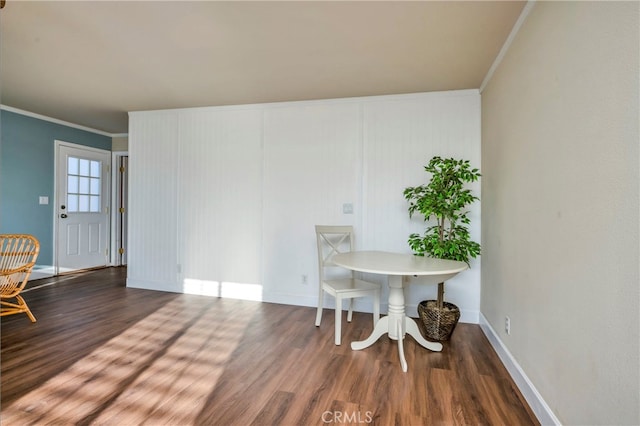 dining space with ornamental molding and dark hardwood / wood-style flooring