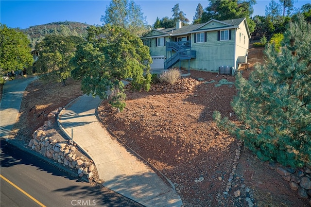 view of front facade featuring a mountain view and central AC