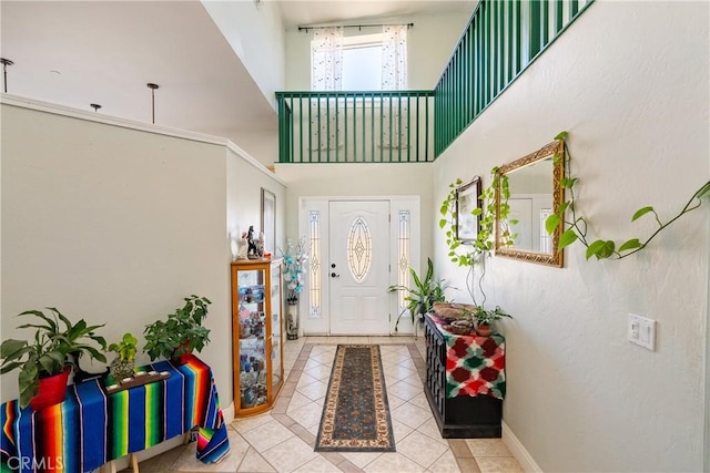 entrance foyer featuring a towering ceiling and light tile patterned floors