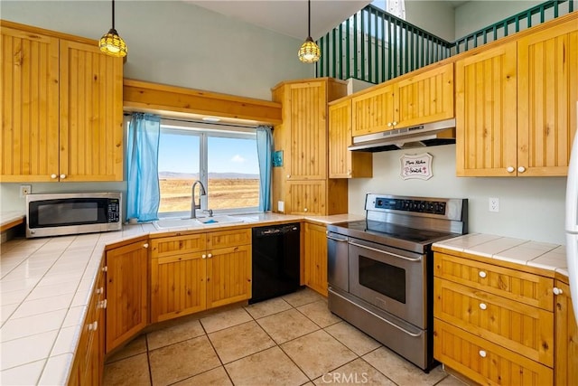 kitchen with pendant lighting, sink, tile countertops, and stainless steel appliances