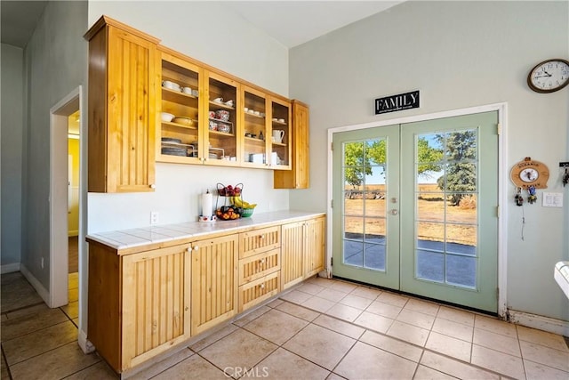 interior space with tile counters, light tile patterned floors, and french doors