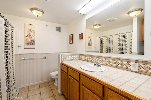 bathroom with tile patterned flooring, vanity, and toilet