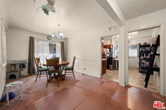 dining space featuring crown molding and a chandelier