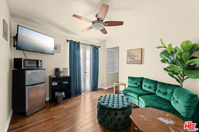 living room with ceiling fan and dark hardwood / wood-style flooring