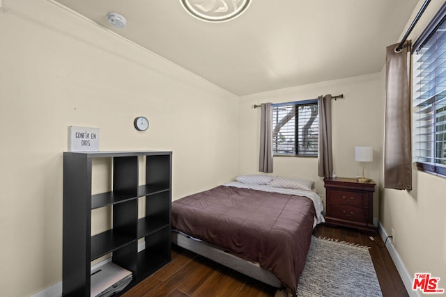 bedroom with dark hardwood / wood-style floors