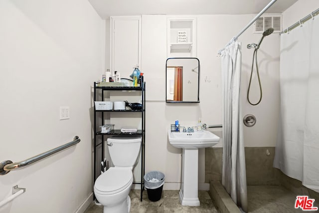 bathroom featuring sink, toilet, and walk in shower