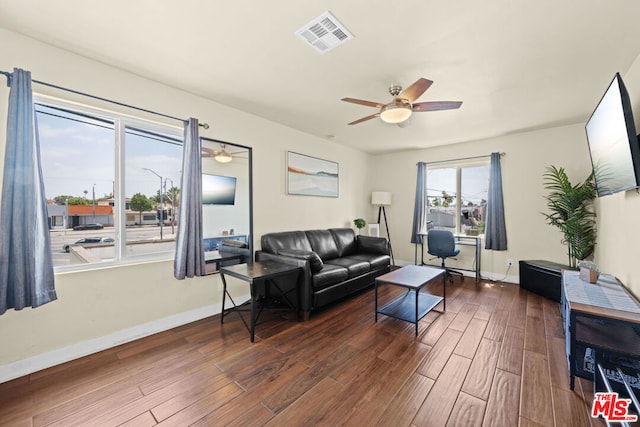 living room featuring ceiling fan and dark wood-type flooring