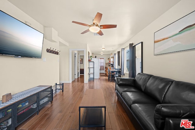 living room featuring ceiling fan and dark wood-type flooring