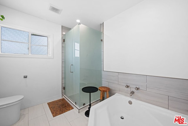 bathroom featuring tile patterned floors, toilet, and shower with separate bathtub