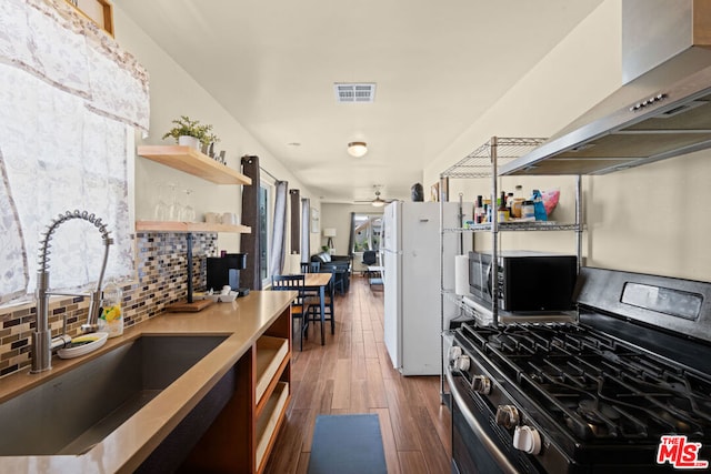 kitchen featuring sink, dark hardwood / wood-style flooring, decorative backsplash, exhaust hood, and appliances with stainless steel finishes