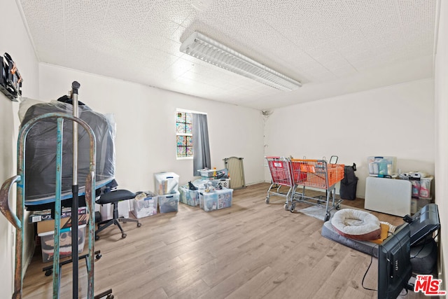 miscellaneous room with a textured ceiling and light wood-type flooring