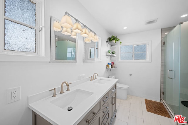 bathroom featuring vanity, toilet, walk in shower, and a healthy amount of sunlight