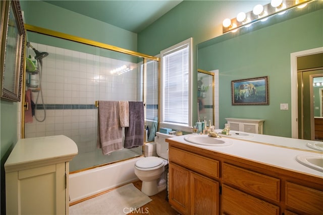 full bathroom featuring bath / shower combo with glass door, vanity, toilet, and wood-type flooring