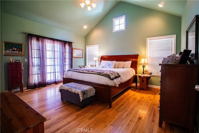 bedroom with light hardwood / wood-style floors and high vaulted ceiling