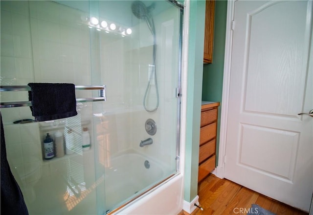 bathroom featuring bath / shower combo with glass door and wood-type flooring