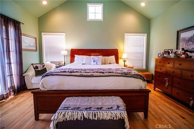 bedroom featuring high vaulted ceiling and light hardwood / wood-style flooring
