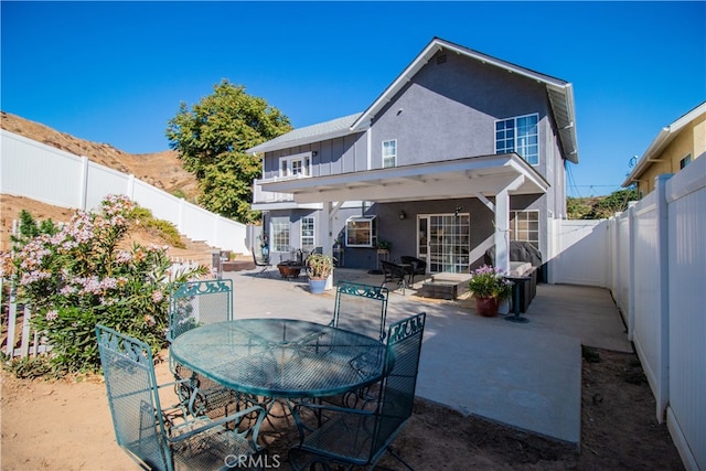 rear view of house with a mountain view and a patio area