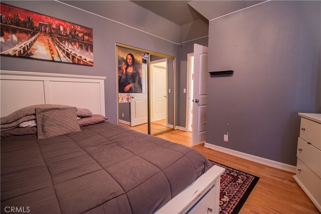 bedroom with light hardwood / wood-style floors and a closet