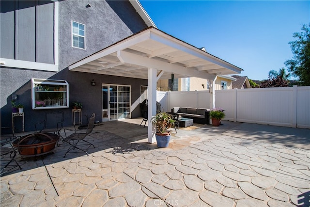 view of patio with an outdoor living space with a fire pit