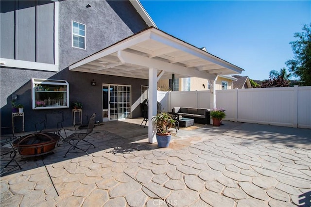 view of patio with an outdoor living space with a fire pit