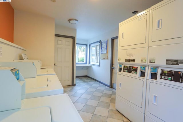 laundry area featuring stacked washer and dryer and light tile patterned floors