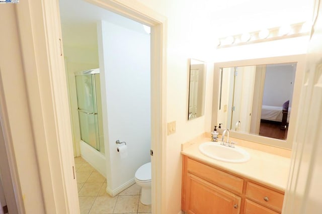 full bathroom featuring tile patterned floors, combined bath / shower with glass door, vanity, and toilet