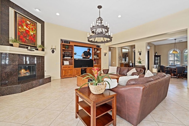 tiled living room with a fireplace and a notable chandelier