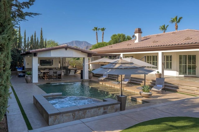 view of swimming pool featuring a mountain view, an in ground hot tub, and a patio