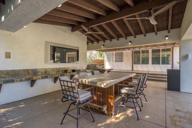 view of patio / terrace featuring ceiling fan, exterior bar, and area for grilling