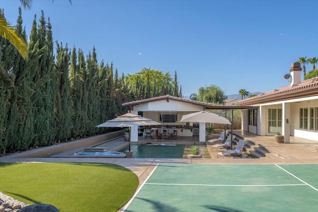 view of home's community with a patio area and a swimming pool with hot tub