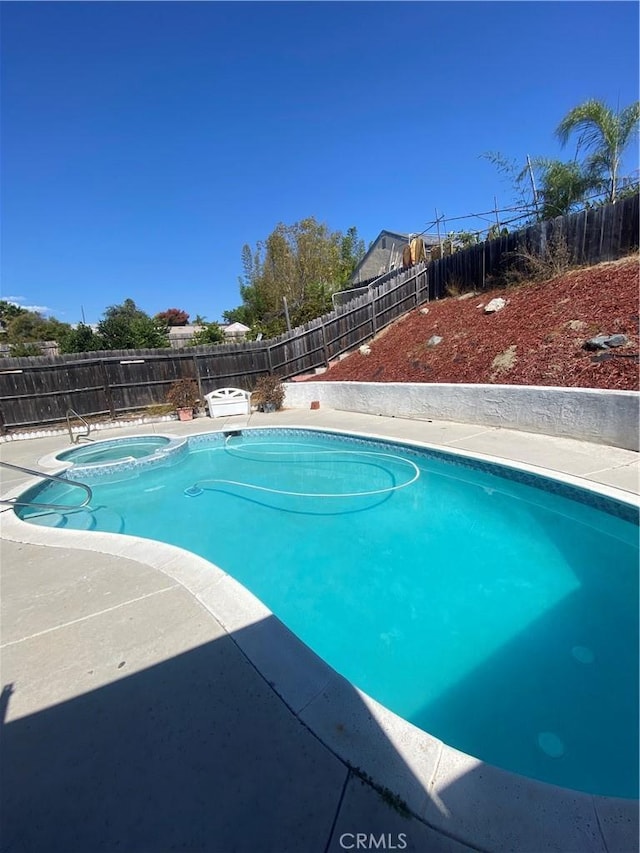 view of pool with an in ground hot tub