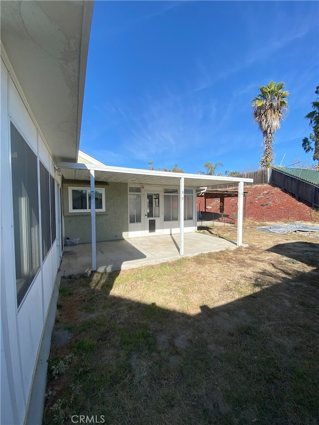 rear view of property featuring a yard and a patio