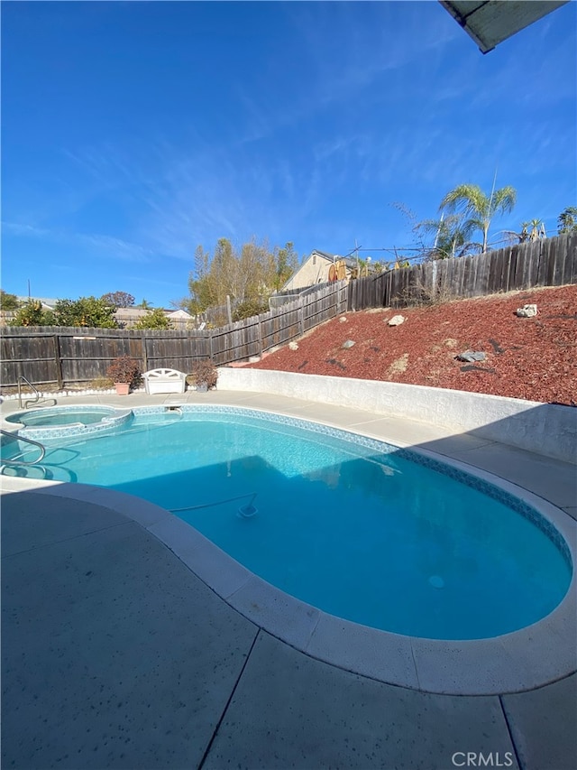 view of swimming pool featuring an in ground hot tub