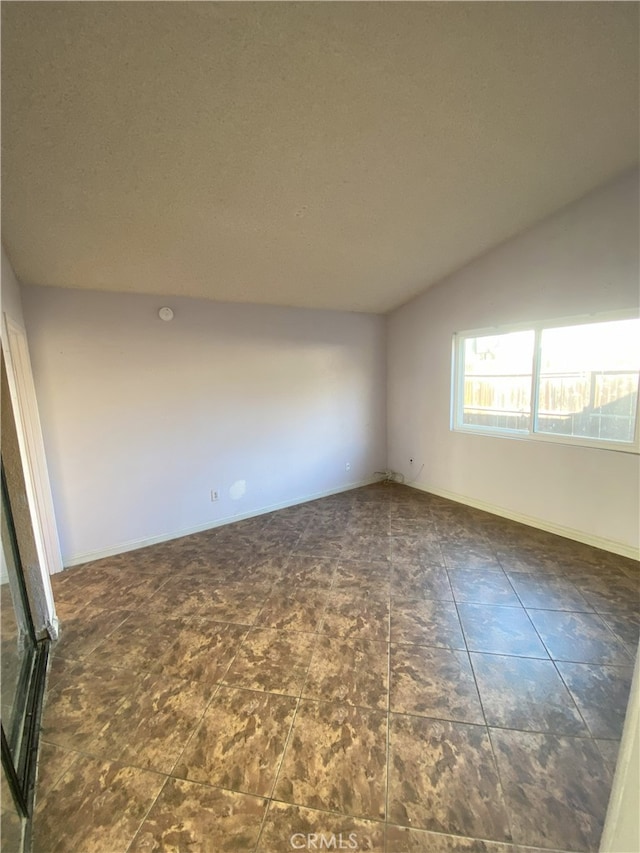 spare room with lofted ceiling