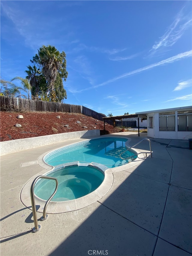 view of swimming pool with a patio area and an in ground hot tub