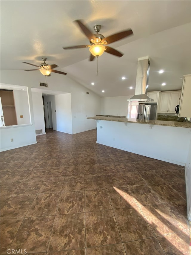 unfurnished living room featuring ceiling fan and vaulted ceiling