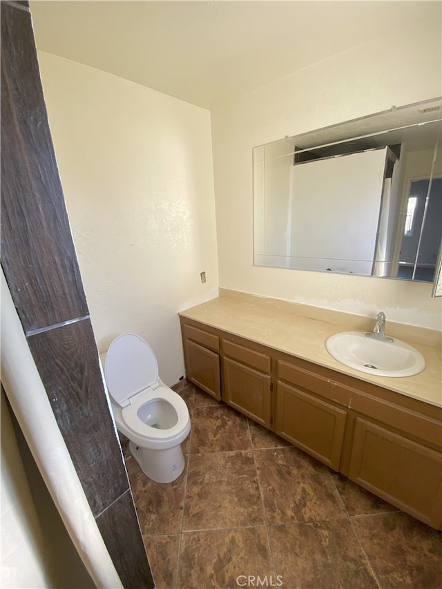 bathroom featuring toilet and vanity