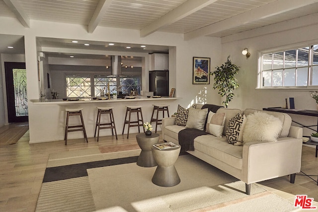 living room with plenty of natural light, beam ceiling, light wood-type flooring, and wooden ceiling