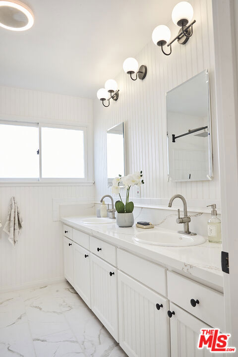 bathroom featuring vanity and wood walls