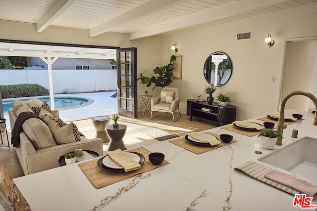 living room featuring beam ceiling, sink, and wooden ceiling