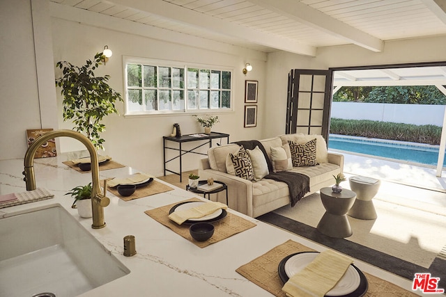 sunroom featuring beam ceiling, wooden ceiling, a healthy amount of sunlight, and sink