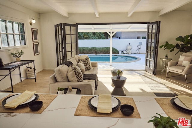 living room featuring beam ceiling, french doors, and wooden ceiling