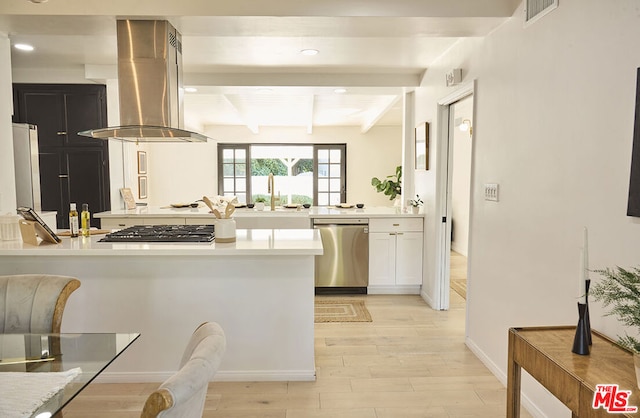 kitchen featuring beamed ceiling, island exhaust hood, appliances with stainless steel finishes, white cabinets, and light wood-type flooring