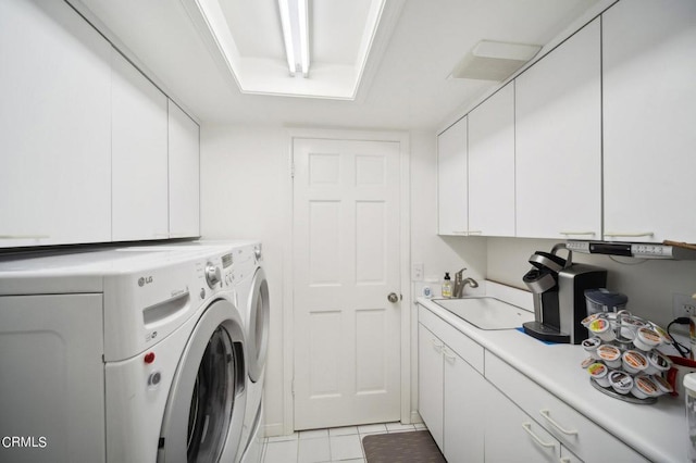 washroom featuring cabinets, sink, light tile patterned floors, and washer and dryer