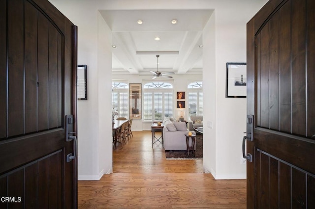 entrance foyer with beam ceiling, ceiling fan, light hardwood / wood-style flooring, and coffered ceiling