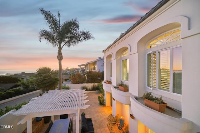 property exterior at dusk featuring a patio