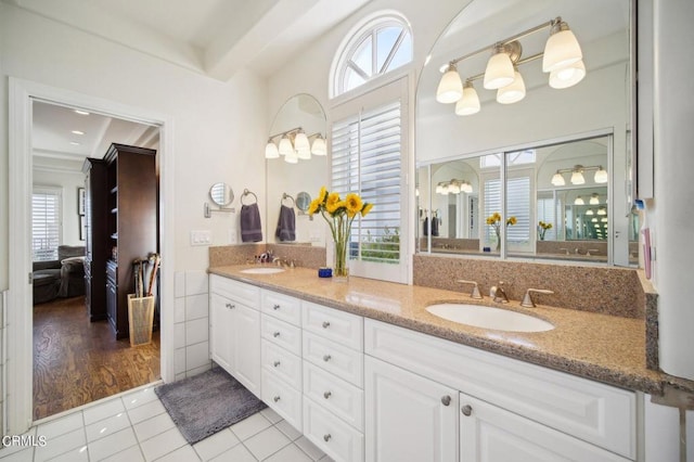 ensuite bathroom with a sink, ensuite bathroom, double vanity, and tile patterned flooring
