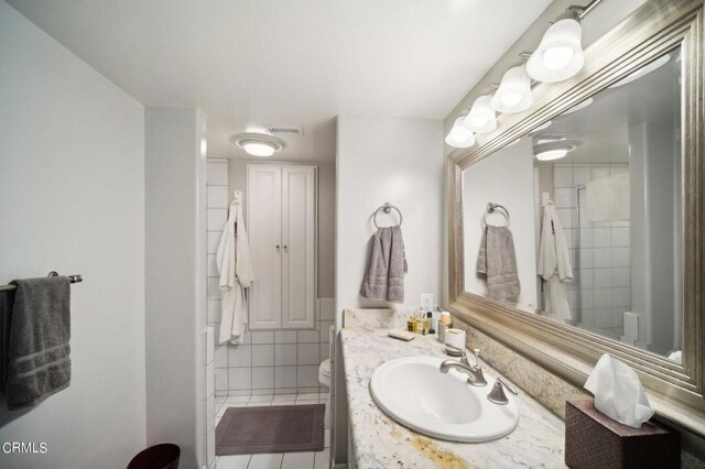 full bath with a shower, visible vents, toilet, and vanity